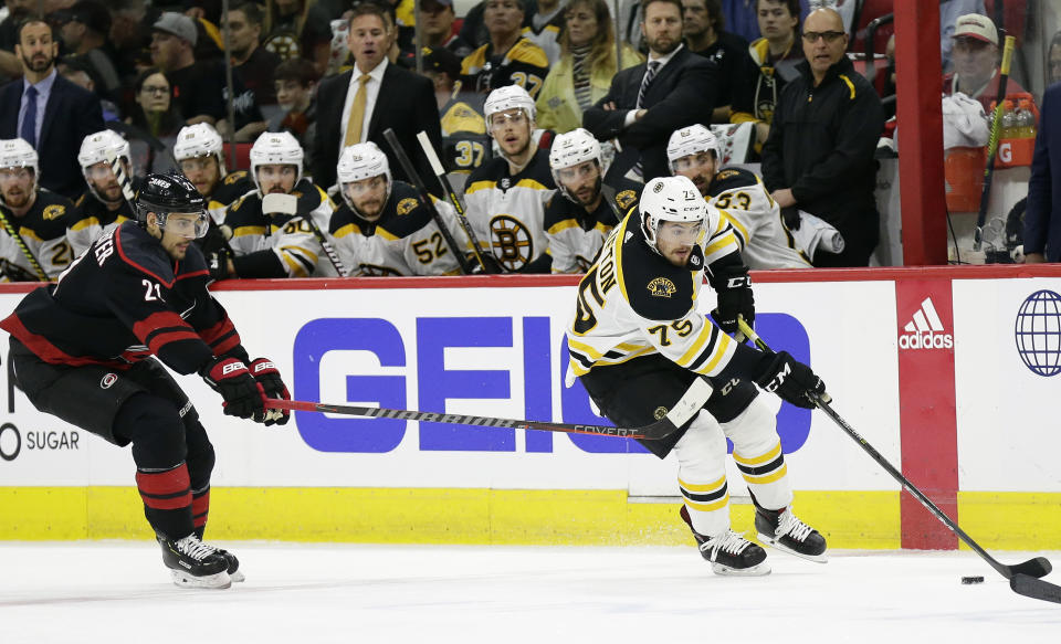 Boston Bruins' Connor Clifton controls the puck while Carolina Hurricanes' Nino Niederreiter (21), of Switzerland, defends during the first period in Game 3 of the NHL hockey Stanley Cup Eastern Conference final series in Raleigh, N.C., Tuesday, May 14, 2019. (AP Photo/Gerry Broome)