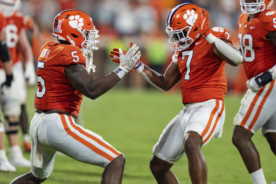 Clemson defensive end K.J. Henry (5) and defensive end Justin Mascoll (7) celebrate after a stop against Louisiana Tech on fourth down during the second half of an NCAA college football game Saturday, Sept. 17, 2022, in Clemson, S.C. (AP Photo/Jacob Kupferman)