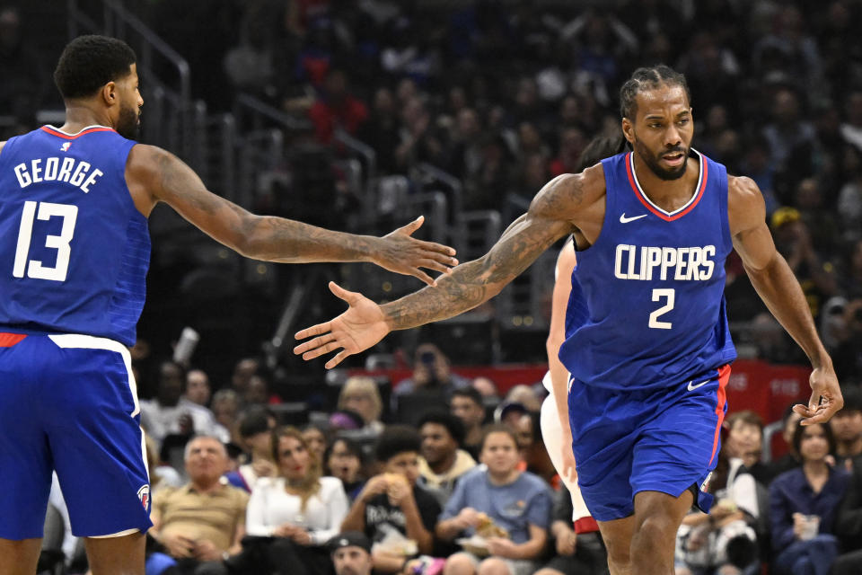 Los Angeles Clippers forward Paul George (13) congratulates forward Kawhi Leonard (2) for a making a basket against the Miami Heat during the first half of an NBA basketball game, Monday, Jan. 1, 2024 in Los Angeles. (AP Photo/Alex Gallardo)