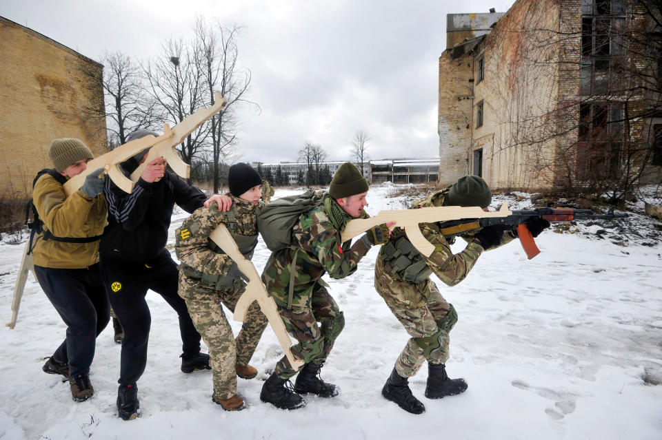 Ukrainians carrying mock weapons attend an open military training for civilians as part of the 