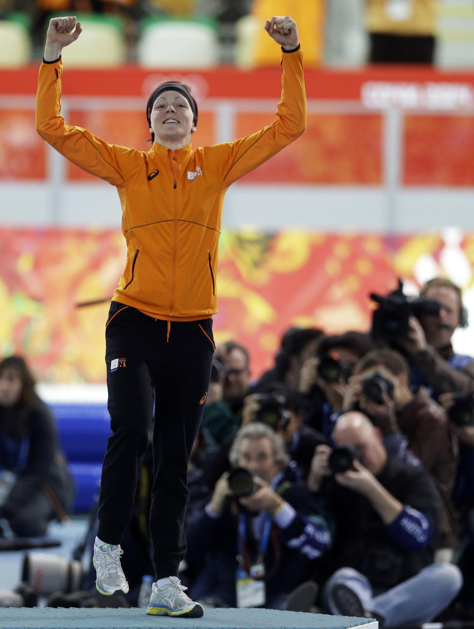 Photographers huddle together to shoot gold medallist Jorien ter Mors of the Netherlands as she jumps in celebration during the flower ceremony for the women's 1,500-meter speedskating race at the Adler Arena Skating Center during the 2014 Winter Olympics in Sochi, Russia, Sunday, Feb. 16, 2014. (AP Photo/Patrick Semansky)