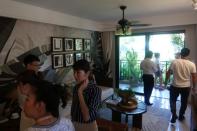 People on a property tour visit a show flat of a real estate property developed by Sunac China Holdings in Xishuangbanna, Yunnan