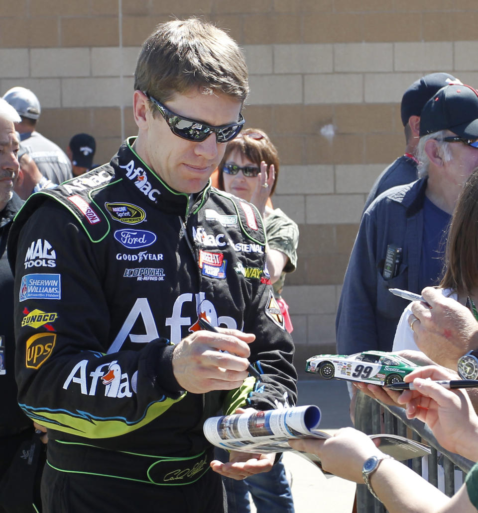 Driver Carl Edwards signs autographs Friday, May 9, 2014, at Kansas Speedway in Kansas City, Kan., for Saturday night's NASCAR Sprint Cup series auto race. (AP Photo/Colin E. Braley)