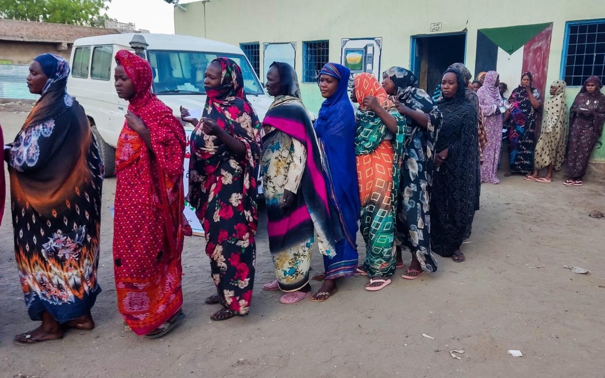 Internally displaced women wait in a queue to collect aid from a group at a camp in Gadaref on May 12