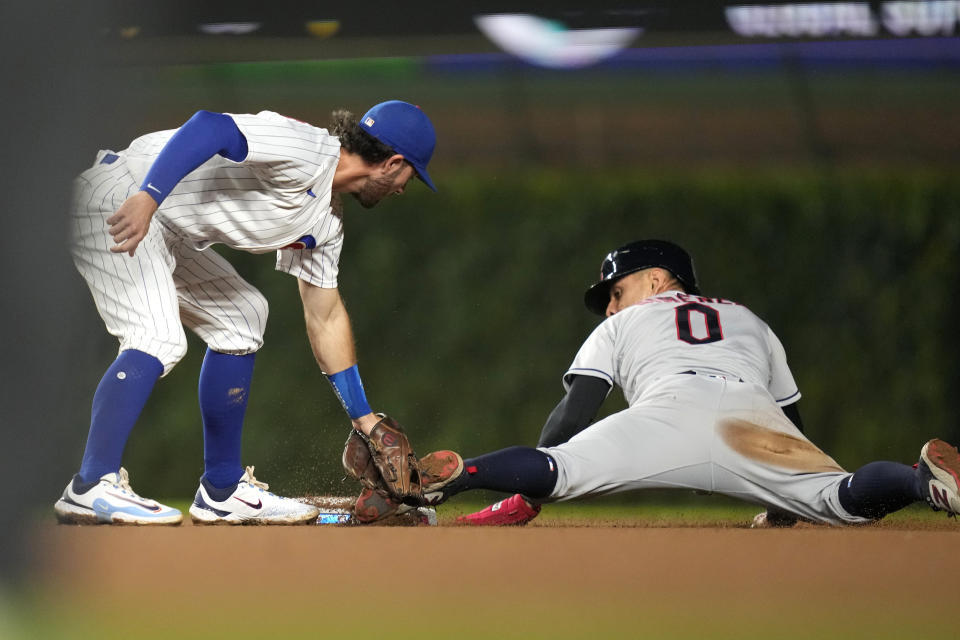 Cleveland Guardians' Andres Gimenez (0) steals second on a throw from Chicago Cubs catcher Tucker Barnhart to shortstop Dansby Swanson during the fourth inning of a baseball game Saturday, July 1, 2023, in Chicago. (AP Photo/Charles Rex Arbogast)