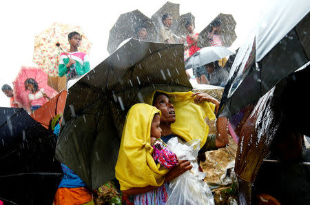 Rohingya refugees wait for aid packages during rain in Cox's Bazar, Bangladesh, September 17, 2017. REUTERS/Mohammad Ponir Hossain