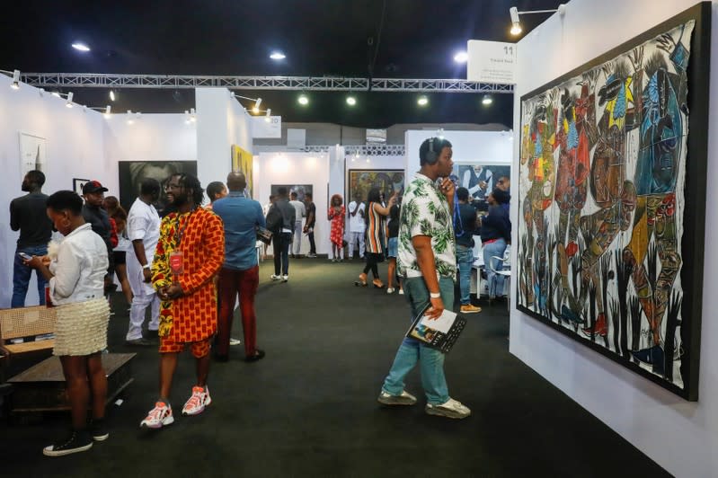 Visitors look at artworks during the Art X in Lagos