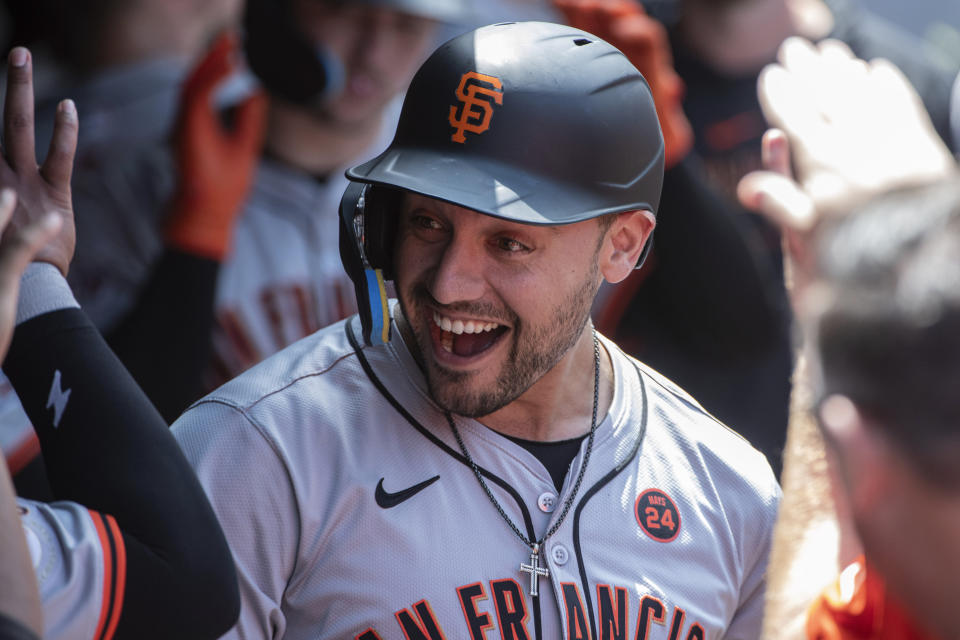 San Francisco Giants' Michael Conforto is congratulated by teammates after hitting a two-run home run off Cleveland Guardians starting pitcher Carlos Carrasco during the second inning of a baseball game in Cleveland, Sunday, July 7, 2024. (AP Photo/Phil Long)