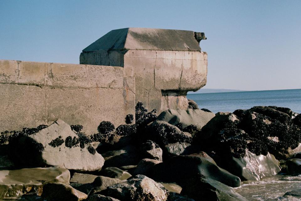 Rocks and a concrete wall at a beach.