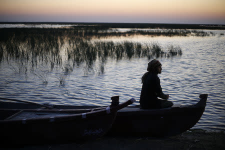 An Iraqi Marsh Arab man sits on a boat at the Chebayesh marsh in Dhi Qar province, Iraq April 13, 2019. REUTERS/Thaier al-Sudani