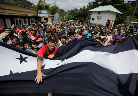 Migrantes hondureños, parte de una caravana que intenta llegar a Estados Unidos, gesticulan al llegar a la frontera entre Honduras y Guatemala, en Agua Caliente, Guatemala, el 15 de octubre del 2018. REUTERS/Jorge Cabrera
