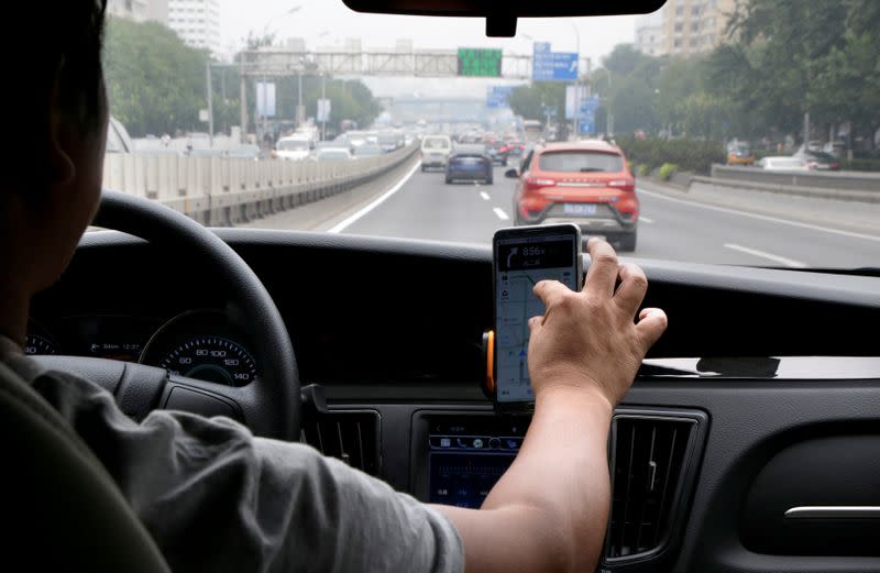 FILE PHOTO: A Didi Chuxing driver Mr. Liu, 37, rides his electric car on the way for service in Beijing