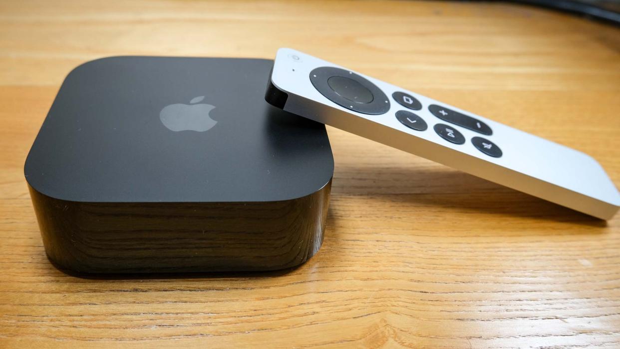  The Apple TV 4K (2022), with the Siri remote propped on its right side. 