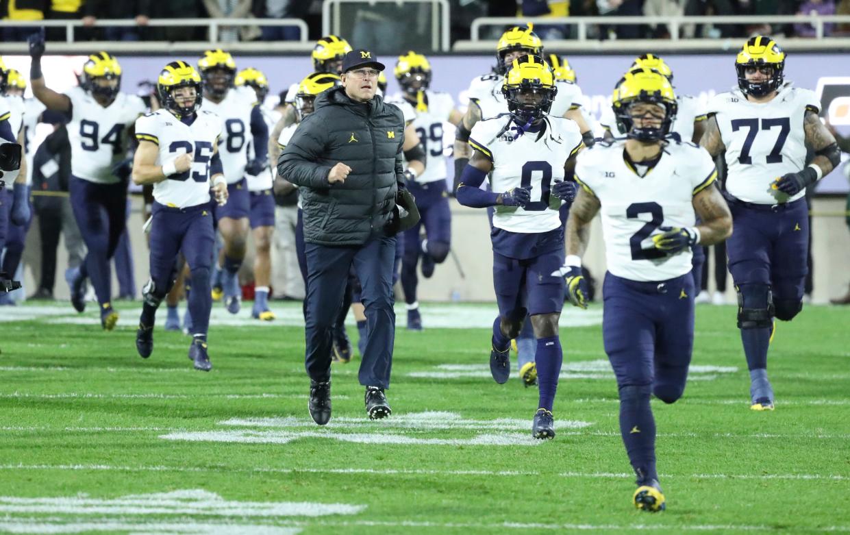 Michigan Wolverines head coach Jim Harbaugh takes the field with his team before action against the Michigan State Spartans at Spartan Stadium in East Lansing on Saturday, Oct. 21, 2023.