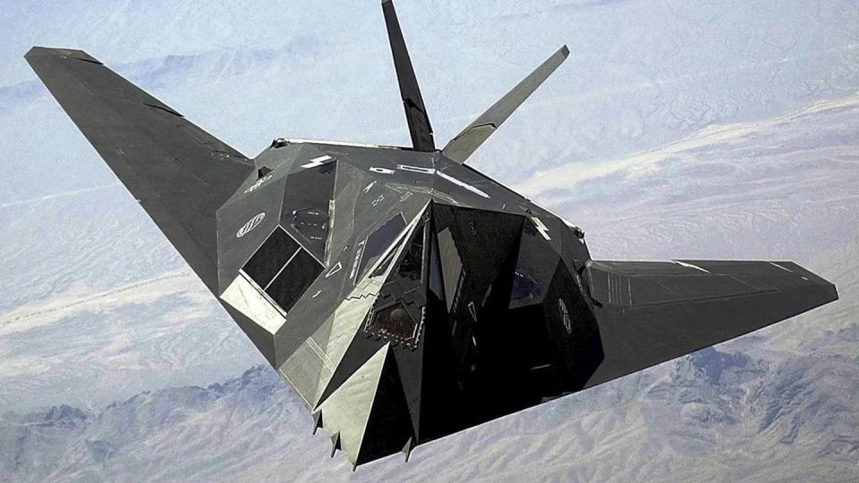 An F-117 Nighthawk flies over the Nevada desert. The unique design of the single-seat F-117 provides exceptional combat capabilities. The fighter can employ a variety of weapons and is equipped with sophisticated navigation and attack systems integrated into a digital avionics suite that increases mission effectiveness and reduces pilot workload. (Staff Sgt. Aaron D. Allmon II/Air Force)