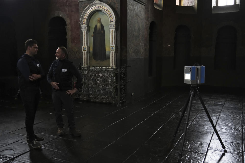 Volunteers Serhii Revenko, left, and Emmanuel Durand talk to each other in the All Saints Church at the Kyiv-Pechersk Lavra in Kyiv, Ukraine, Sunday, June 11, 2023. Using high-tech laser gear, a United Nations-backed team is scanning Ukraine historical sites to preserve them amid Russia's war on the country. (AP Photo/Jon Gambrell)