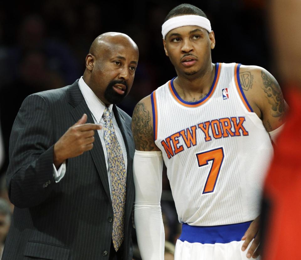 New York Knicks head coach Mike Woodson talks to Carmelo Anthony, right, during the first half of an NBA basketball game against the Toronto Raptors, Wednesday, Feb. 13, 2013, in New York. (AP Photo/Frank Franklin II)