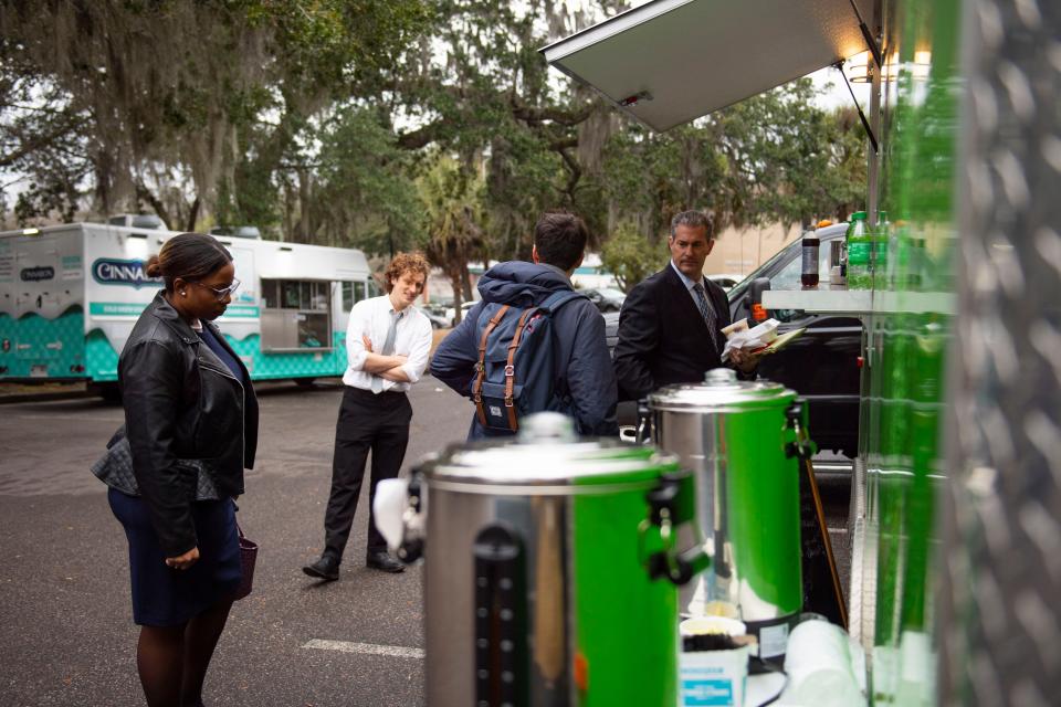 People order from Blazin's Blaine's Deep Fried Goodies food truck on Wednesday, Jan. 25, 2023. A parking lot across from the courtroom is filled with food trucks where lawyers, sheriffs, journalists and onlookers gather for lunch during Alex Murdaugh's trial at the Colleton County Courthouse. 