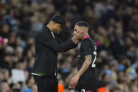FILE - Burnley head coach Vincent Kompany, left, speaks with Burnley's Vitinho during the English FA Cup quarterfinal soccer match against Manchester City at Etihad Stadium in Manchester, England, Saturday, March 18, 2023. Racism has long permeated the world’s most popular sport, with soccer players subjected to racist chants and taunts online. While governing bodies like FIFA and UEFA have taken steps to combat the abuse of players, the lack of diversity in the upper ranks at major clubs remains an unsolved problem. (AP Photo/Jon Super, File)