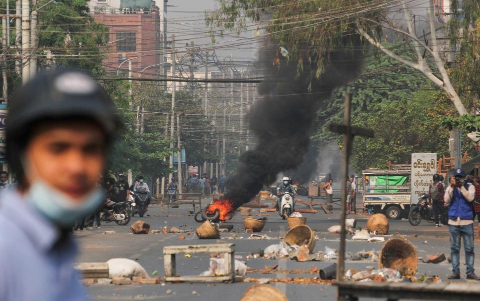 Tires burn on a street as protests against the military coup continue in Mandalay - REUTERS