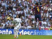 Barcelona's Luis Suarez (R) heads the ball as Real Madrid's Sergio Ramos looks on during their Spanish first division "Clasico" soccer match at the Santiago Bernabeu stadium in Madrid October 25, 2014. REUTERS/Sergio Perez (SPAIN - Tags: SOCCER SPORT)