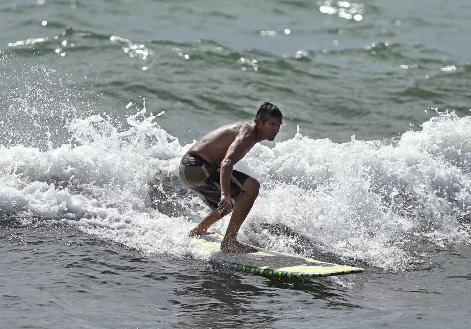 A surfer takes advantage of waves on Saturday, August 31, 2019 at Dania Beach in Florida. As of the 11 a.m. advisory, Hurricane Dorian is a category 4 storm. (David Santiago/Miami Herald via AP)