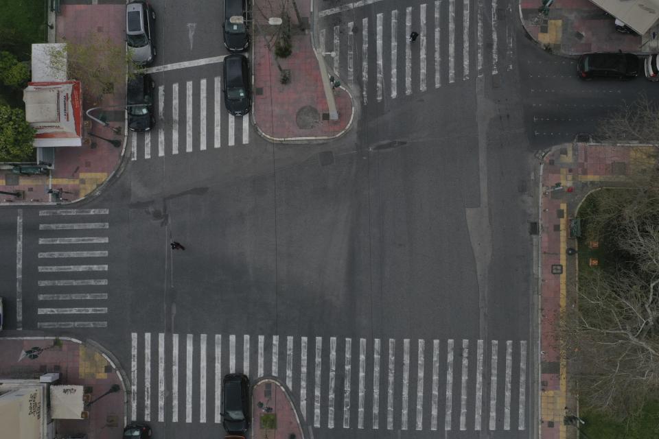 In this Wednesday, April 1, 2020 photo, pedestrians walk in Akadimias street in central Athens. Deserted squares, padlocked parks, empty avenues where cars were once jammed bumper-to-bumper in heavy traffic. The Greek capital, like so many cities across the world, has seen its streets empty as part of a lockdown designed to stem the spread of the new coronavirus. (AP Photo/Thanassis Stavrakis)