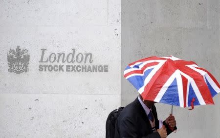 Un uomo con i colori dell'Union Flag sull'ombrello davanti alla Borsa di Londra. REUTERS/Toby Melville/File Photo