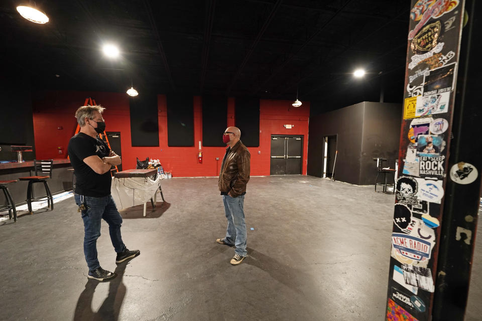 Mike Grimes, left, and Dave Brown, co-owners of The Basement East, talk inside the rebuilt music venue Thursday, Feb. 25, 2021, in Nashville, Tenn. The building was destroyed by a tornado March 3, 2020, and the difficulties of reopening were compounded by COVID-19. Now, as the anniversary of the two catastrophic events approaches, the owners hope to reopen their doors, this time with masks and tables spread out throughout their 5,000 square foot space. Amid signs that the virus is slowing its spread and more people are getting vaccines, they've set their sights on spring. (AP Photo/Mark Humphrey)