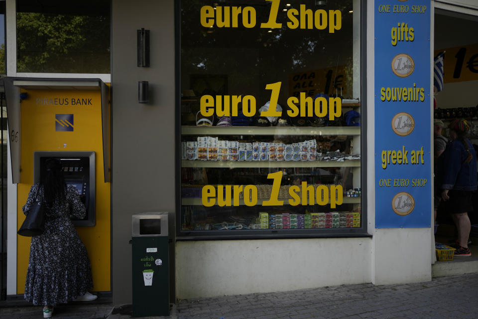 FILE - A woman uses an ATM machine in the main town of the Aegean Sea island of Rhodes, southeastern Greece, Tuesday, May 10, 2022. Inflation in 19 European countries using the euro currency hits another record at 10% as energy prices soar. (AP Photo/Thanassis Stavrakis, File)