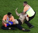 Security guards grab a fan who ran onto the pitch during the 2014 World Cup final between Germany and Argentina at the Maracana stadium in Rio de Janeiro July 13, 2014. REUTERS/Francois Xavier Marit