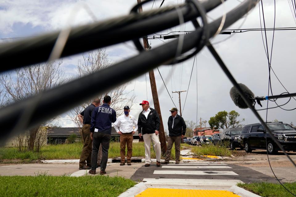 President Donald Trump speaks with Gov. John Bel Edwards and others as he tours damage from Hurricane Laura, Saturday, Aug. 29, 2020, in Lake Charles, La. (AP Photo/Alex Brandon)