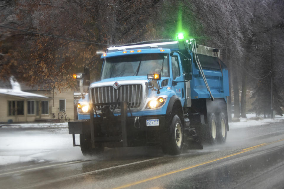 A salt truck drives in freezing rain on Lake Harbor Road in Norton Shores, Mich., on Monday, Feb. 27, 2023. (Cory Morse/MLive.com/The Grand Rapids Press via AP)