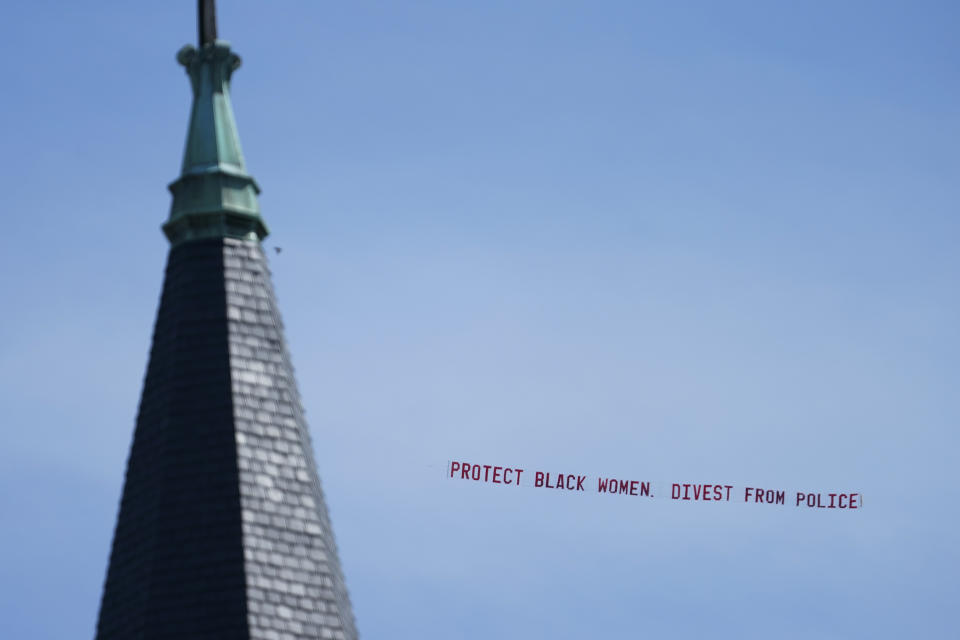 A plane flying a banner reading "Protect Black Women. Divest from Police." flies over Churchill Downs before the 147th running of the Kentucky Derby, Saturday, May 1, 2021, in Louisville, Ky. (AP Photo/Brynn Anderson)