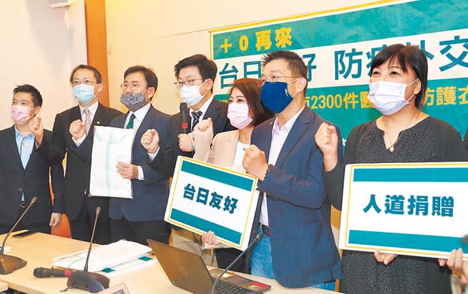 民進黨立委郭國文（中）等人28日舉行記者會，宣布捐贈2300件醫療級防護衣給大阪市政府，並和與會的日本台灣交流協會副代表西海茂洋（左二）等人一起喊口號。（劉宗龍攝）