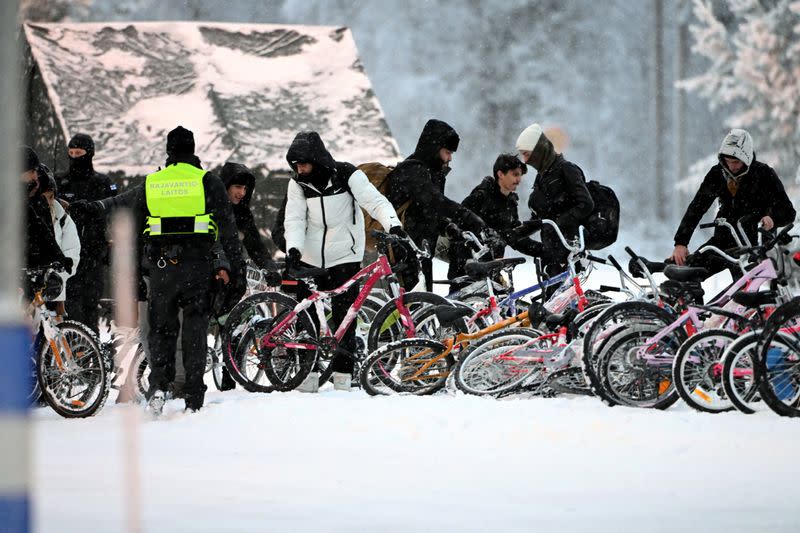 FILE PHOTO: Migrants arrive with bicycles to the international border crossing at Salla