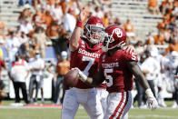 Oklahoma quarterback Spencer Rattler (7) congratulates running back T.J. Pledger (5) after Pledger scored against Texas during the second half of an NCAA college football game in Dallas, Saturday, Oct. 10, 2020. Oklahoma defeated Texas 53-45 in four overtimes. (AP Photo/Michael Ainsworth)