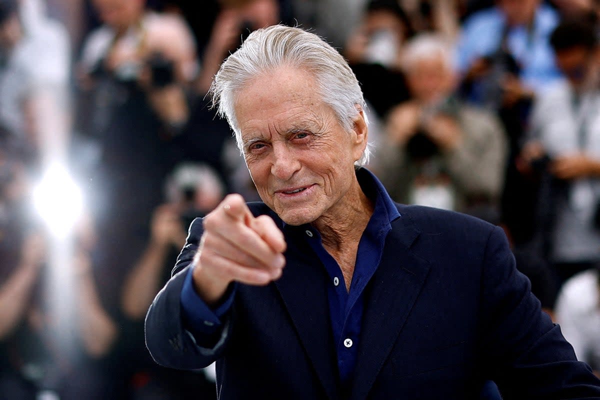 Michael Douglas poses before being awarded with an honorary Palme d'Or prize during the opening ceremony of the 76th Cannes on 16 May 2023 (Reuters)