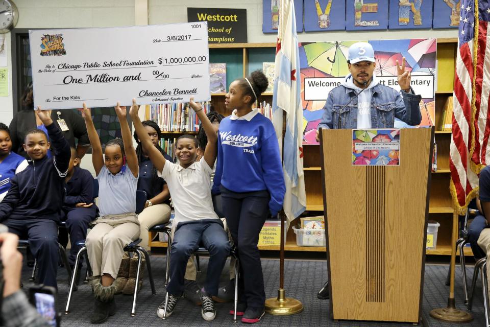 Chance The Rapper, right, announces a gift of $1 million to the Chicago Public School Foundation during a news conference at the Westcott Elementary School, Monday, March 6, 2017, in Chicago. The Grammy-winning artist is calling on Illinois Gov. Bruce Rauner to use executive powers to better fund Chicago Public Schools. (AP Photo/Charles Rex Arbogast)