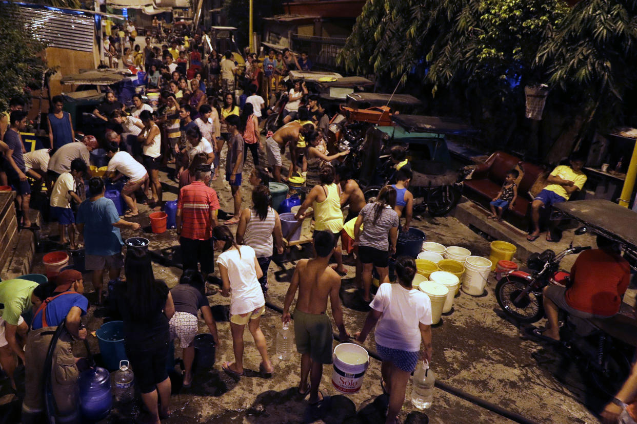 Residents line up to get water brought by a firetruck after their supply has been out for the past days in Mandaluyong, Metro Manila, Philippines. (AP Photo/Aaron Favila)