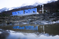FILE - A Sochi 2014 logo of the 2014 Winter Olympics standing amid mud and rubble in front of snow-covered mountains is reflected in a puddle, in Krasnaya Polyana, Russia on Feb. 3, 2014. How did Beijing land the Winter Olympics, so soon after it was host to the Summer Olympics in 2008? Potential cities in Europe dropped out of the bidding in the wake of the scandal-ridden 2014 Winter Olympics in Sochi, Russia. The widely advertised price tag for Sochi of $51 billion also frightened away bidders. (AP Photo/Gero Breloer, File)