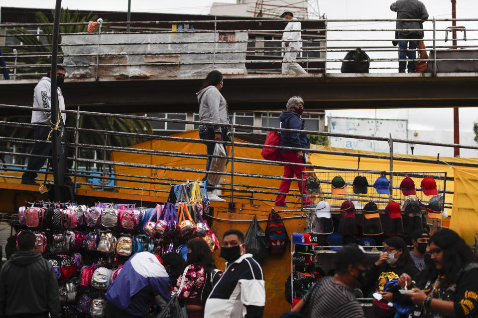 People walk past vendors' stalls outside Mercado Sonora, which reopened ten days ago with measures to reduce congestion and limit spread of the coronavirus, in Mexico City, Thursday, June 25, 2020. (AP Photo/Rebecca Blackwell)