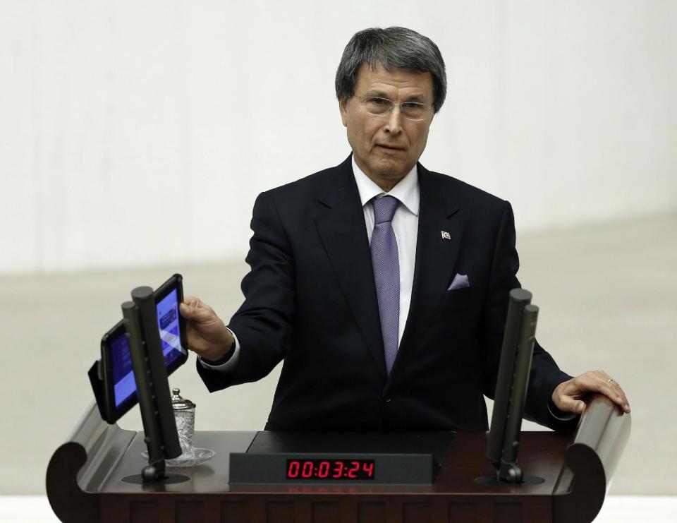 Yusuf Halacoglu, a deputy from the opposition Nationalist Action Party, MHP, plays a recording of a wiretapped conversation allegedly between Prime Minister Recep Tayyip Erdogan and a manager of a television station that reportedly was leaked onto the Internet, during a parliamentary debate late Wednesday, Feb. 5, 2014, shortly before legislators approved measures that would tighten government controls over the Internet. With a show of hands, the legislators late Wednesday endorsed allowing Turkey's telecommunications authority to block websites for a privacy violation without a prior court decision.(AP Photo)