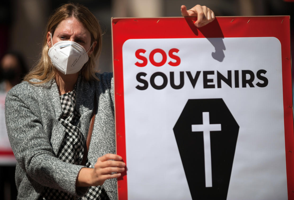 A protester wearing a mask holds a placard at Plaza de la Constitucion square during the demonstration in Malaga, Spain. Employees from S.O.S Souvenirs association who work in tourists souvenir stores, demand that the Spanish government ensures the survival of this industry. Photo: Jesus Merida/SOPA/LightRocket via Getty