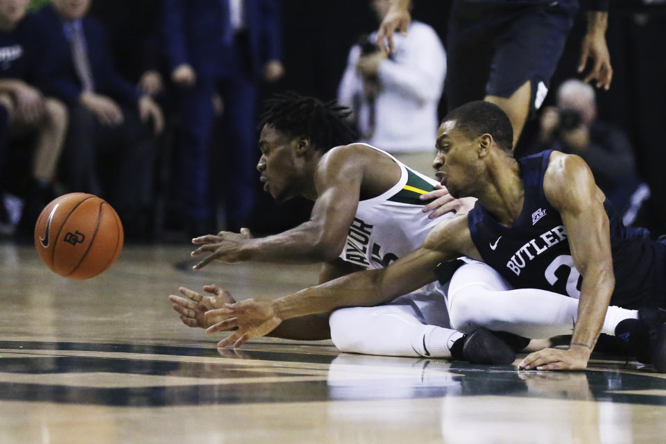 Baylor guard Davion Mitchell, left, reaches for a loose ball with Butler guard Aaron Thompson in the first half of an NCAA college basketball game, Tuesday, Dec. 10, 2019, in Waco, Texas. (AP Photo/Rod Aydelotte)