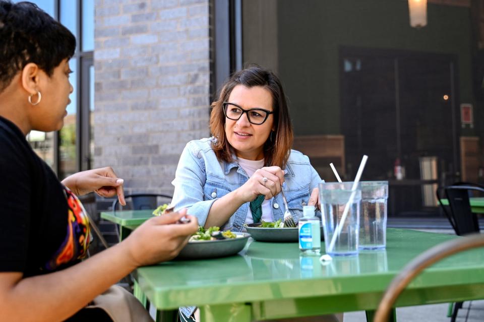 Matea Caulk, right, and Triquita Hicks enjoy lunch outside the Jolly Pumpkin on Friday, May 26, 2023, in downtown East Lansing.