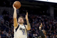 Dallas Mavericks guard Luka Doncic (77) shoots against Golden State Warriors forward Jonathan Kuminga (00) during the first half of an NBA basketball game in San Francisco, Tuesday, Jan. 25, 2022. (AP Photo/Jed Jacobsohn)