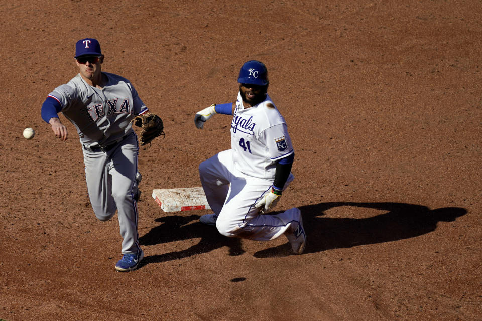 Texas Rangers second baseman Nick Solak throws to first too late for the double play on a ball hit by Kansas City Royals' Salvador Perez, after forcing Carlos Santana (41) out at second during the second inning of a baseball game Thursday, April 1, 2021, in Kansas City, Mo. (AP Photo/Charlie Riedel)