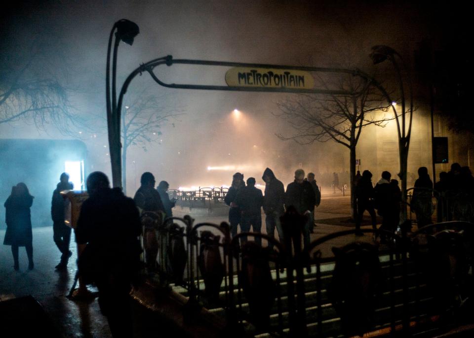 People stand next to the entrance of a metro station at the end of a demonstration in Paris (AP)