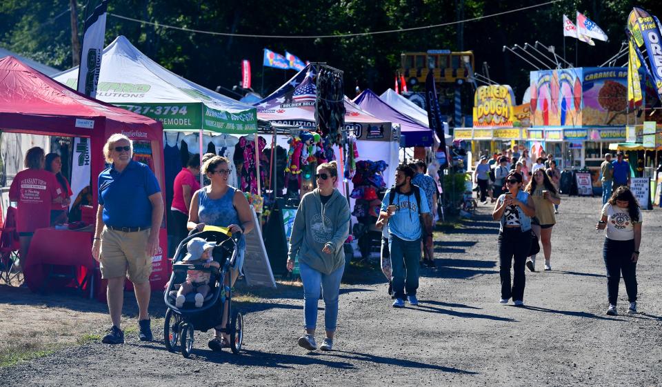 Visitors stroll at the Lancaster Fairgrounds early Saturday morning during the Bolton Fair.